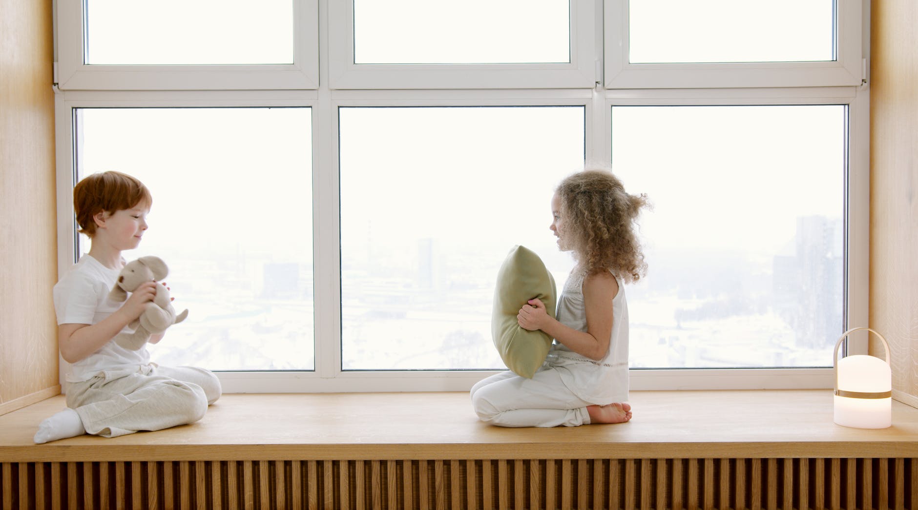 kids having a conversation while sitting on a windowsill