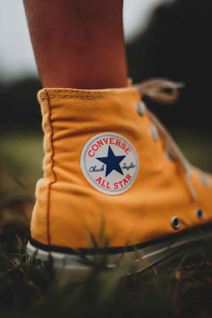 person wearing orange converse all star high top sneakers