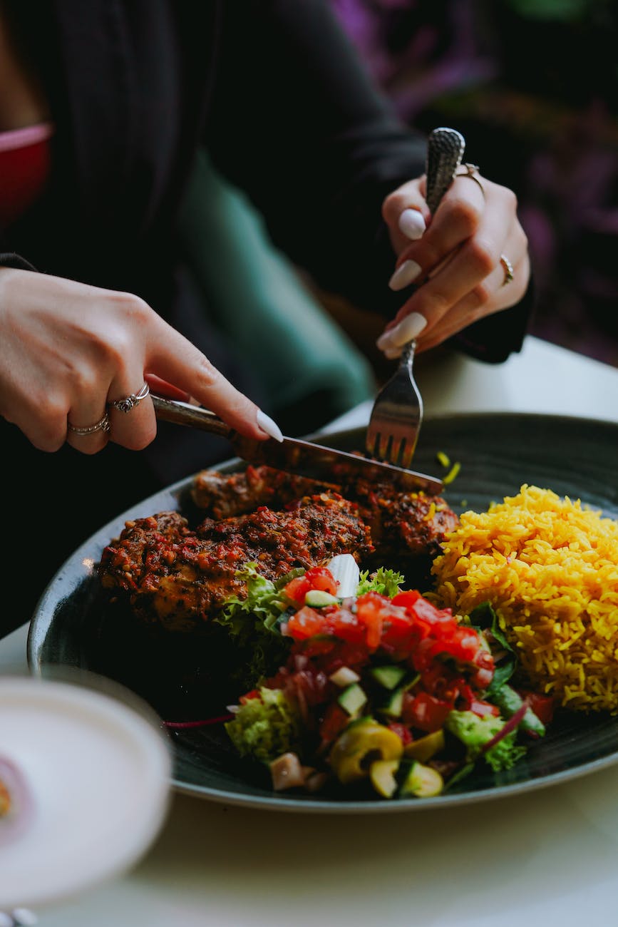 close up of woman cutting food on the plate