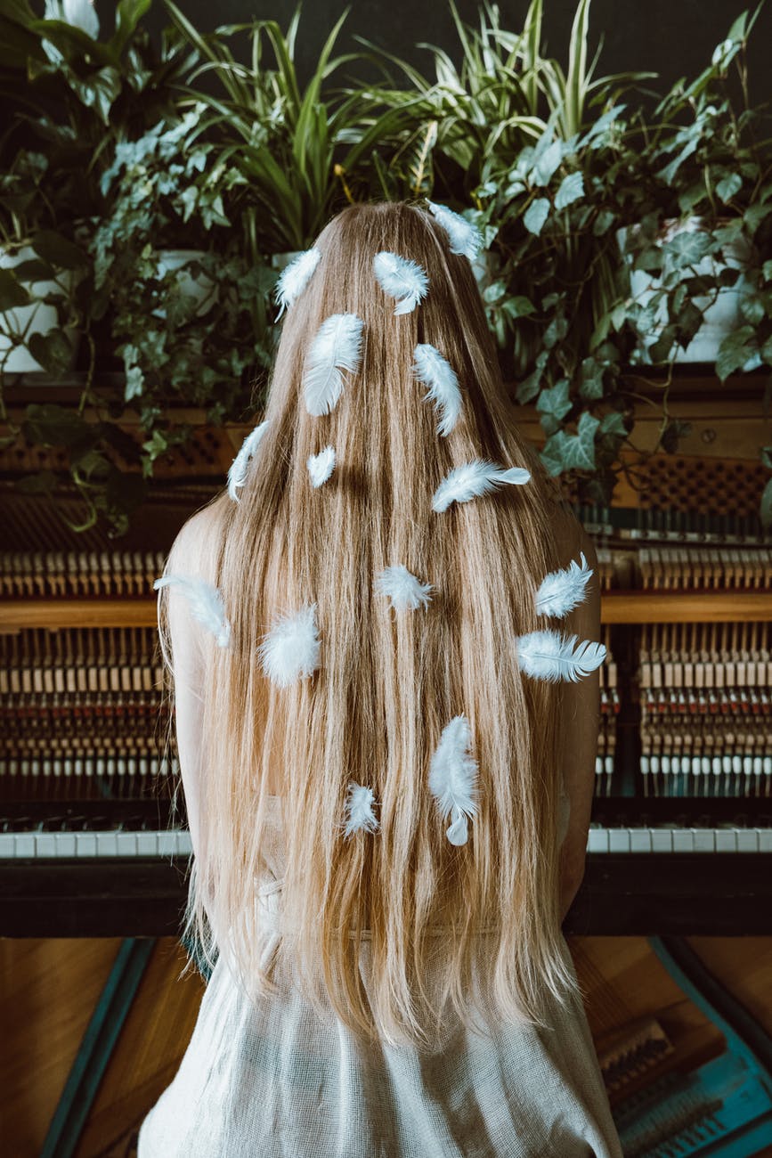 woman with long blond hair with feathers