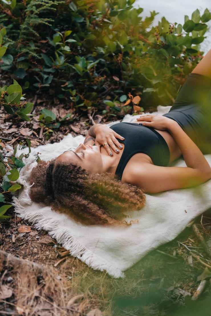 woman wearing black tank top lying on white towel